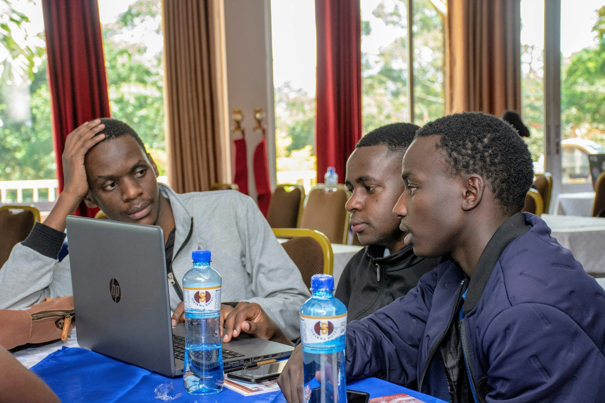 A Kenyan team collaborating around laptops in a bright workspace